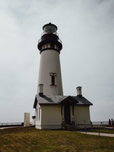 A white and black lighthouse on a cloudy day.