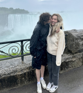 Two women stand in front of Niagara Falls